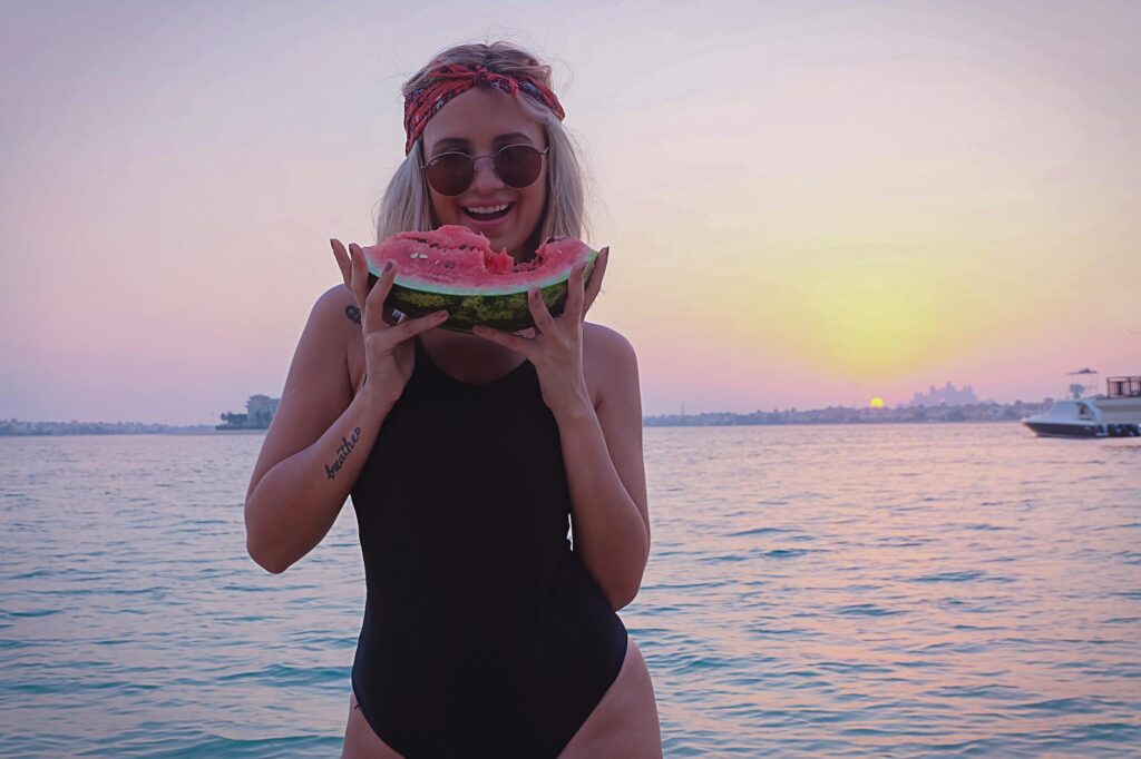 woman holding slice of watermelon