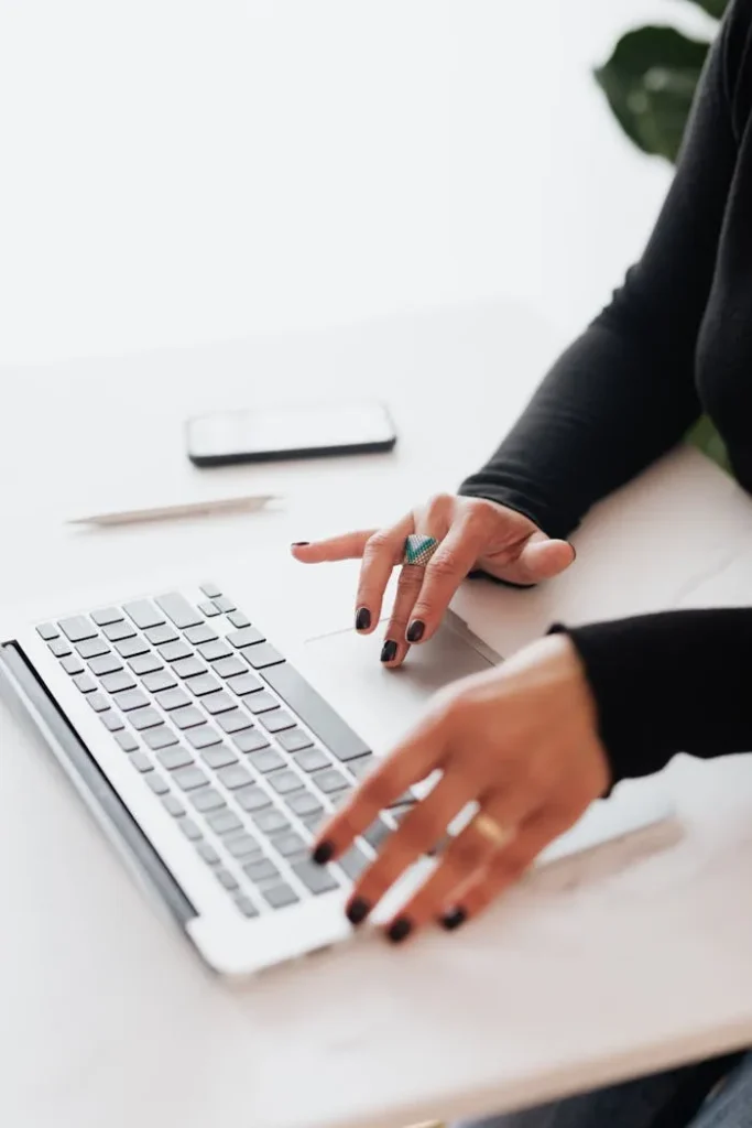 Woman's hand on a laptop, reading an educational e-book purchased from Filip Digital.